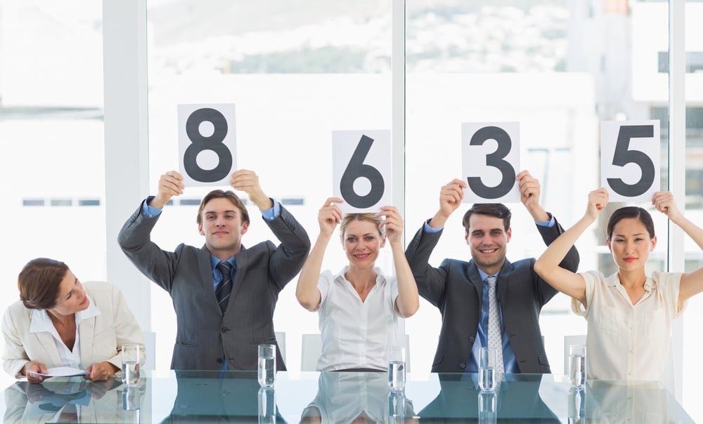 Portrait of a group of panel judges holding score signs