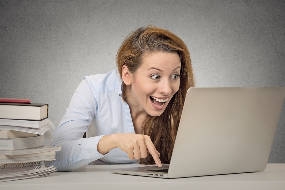 Woman_excited_expression_face_laptop_books_office_worker.jpeg